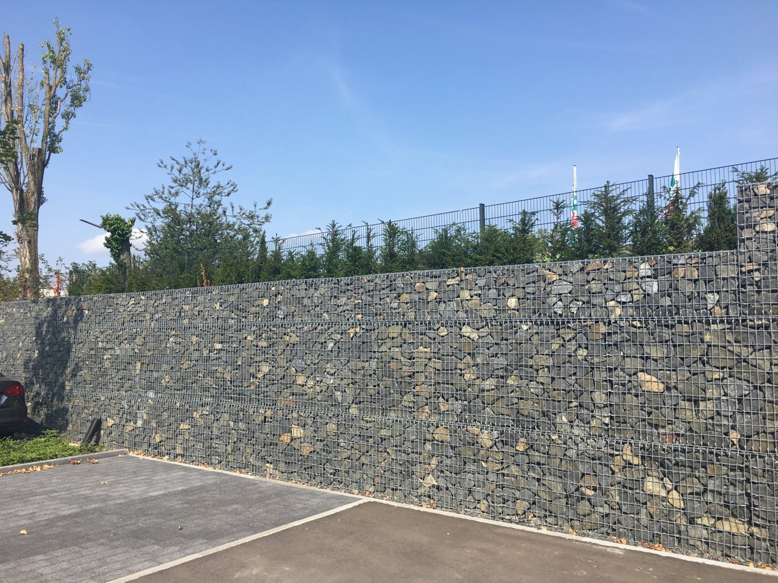 Gabionenwand als Stützmauer an einem Parkplatz